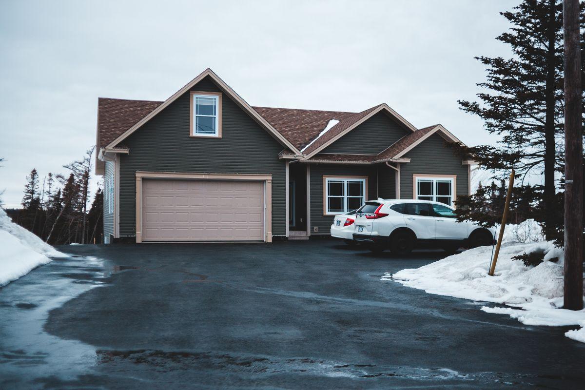 A house with a cleared asphalt driveway after snow